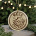 A circular ornament with the text "Mesa Arizona USA" printed on it, featuring a mountain and desert landscape.