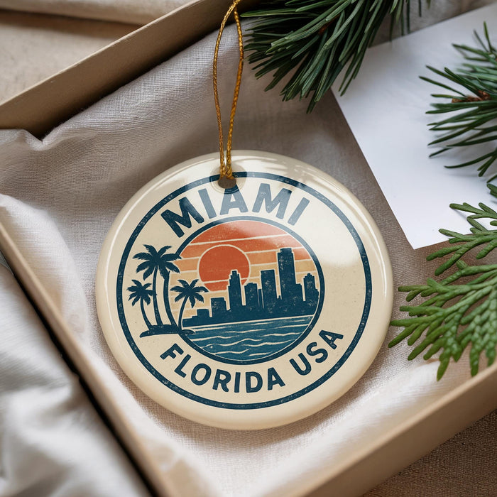 A round ornament with a graphic design featuring a city skyline and palm trees, with the text "MIAMI FLORIDA USA" printed on it.