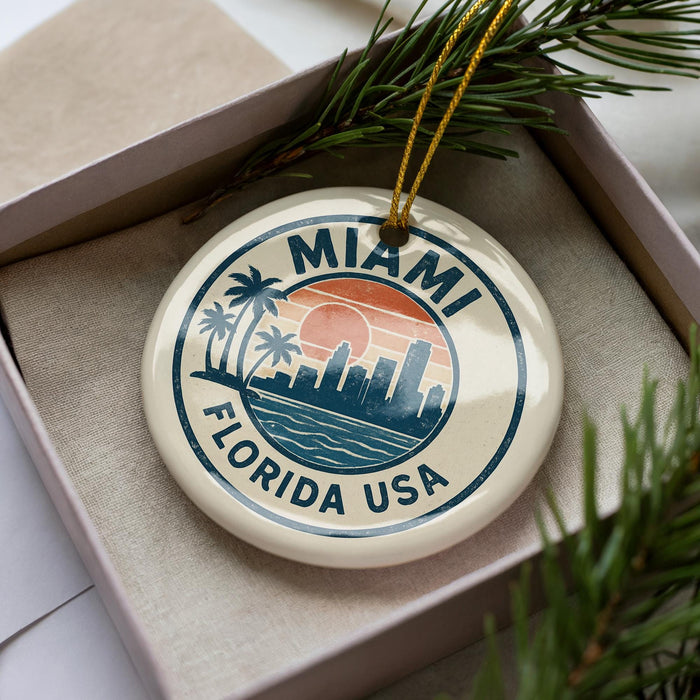 A circular ornament with the text "MIAMI FLORIDA USA" printed on it, surrounded by palm trees and a sunset.