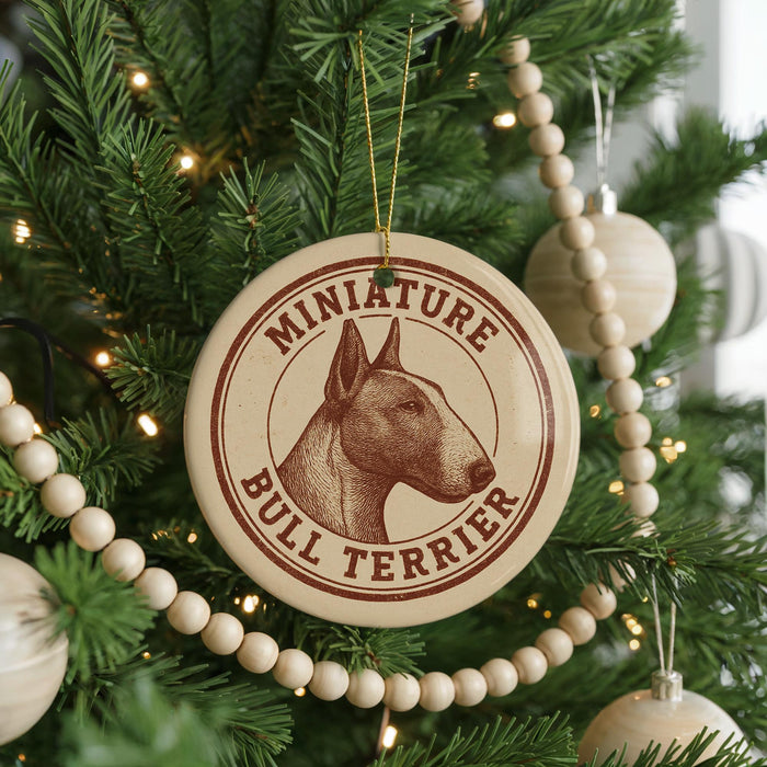 A Christmas tree decorated with ornaments, including a circular ornament with a bull terrier image and the text "Miniature Bull Terrier".