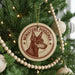 A Christmas tree decorated with ornaments, including a circular ornament with a dog's head and the text "MINIATURE PINSCHER" printed on it.