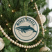 A Christmas tree decorated with ornaments, including a circular ornament with a blue whale image and the text "MINKE WHALE" around the edge.