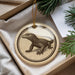 A circular ornament featuring a detailed illustration of a lizard or salamander, hanging from a string.