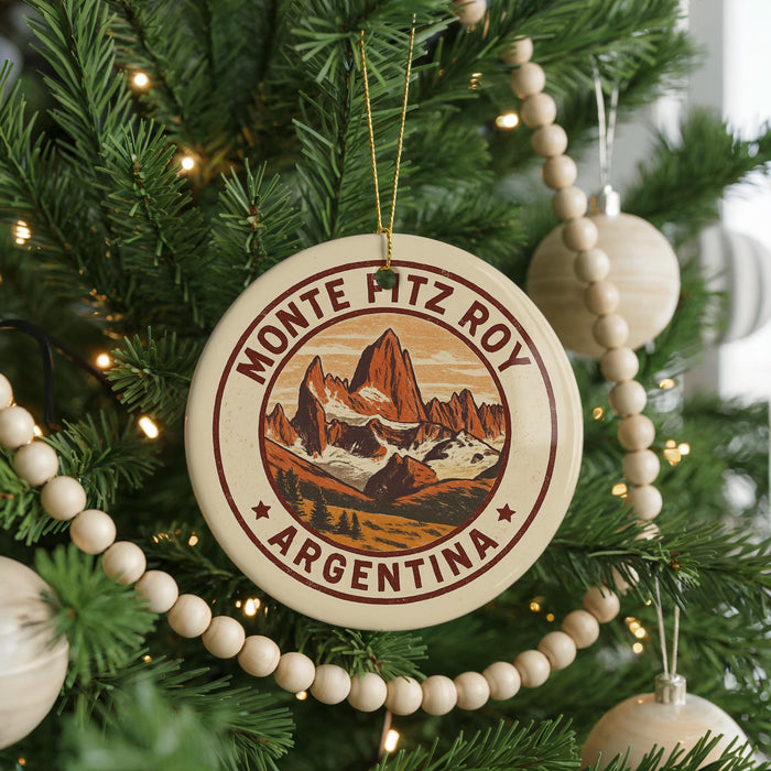 A Christmas tree decorated with ornaments, including a circular ornament with a mountain landscape and the text "MONTE PITZ ROY ARGENTINA".