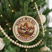 A Christmas tree decorated with ornaments, including a circular ornament with a mountain landscape and the text "MONTE PITZ ROY ARGENTINA".