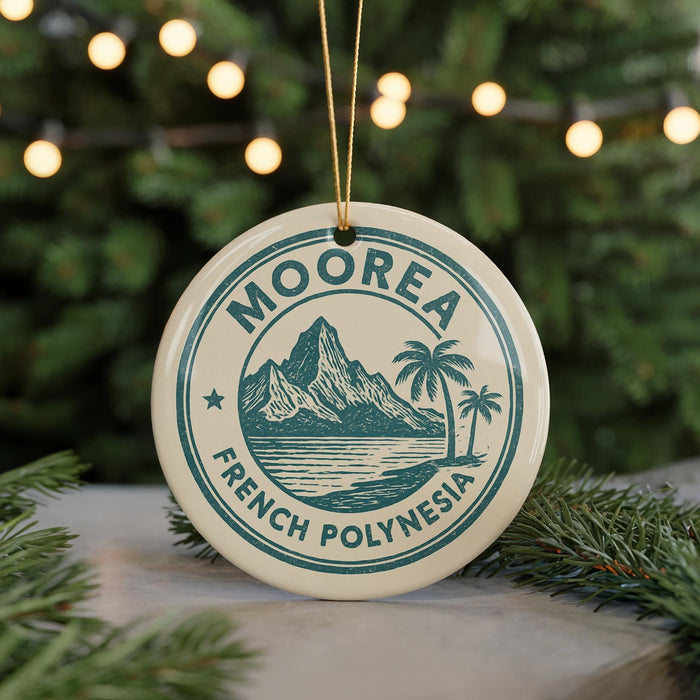 A circular ornament with the text "MOOREA FRENCH POLYNESIA" printed on it, hanging from a string.