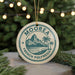 A circular ornament with the text "MOOREA FRENCH POLYNESIA" printed on it, hanging from a string.