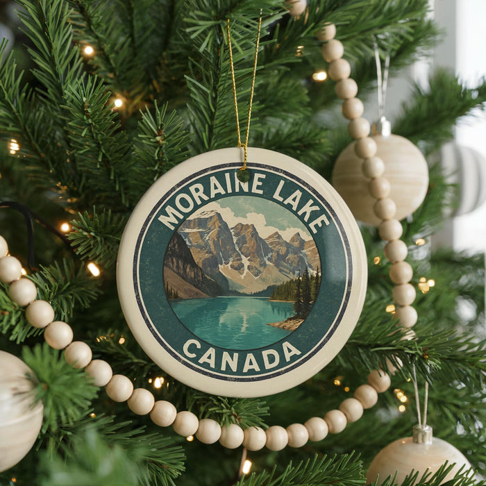 A Christmas tree decorated with ornaments, including a circular ornament with a mountain landscape and a lake, and a beaded ornament.
