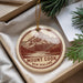 A round ornament with a mountain landscape and the text "Mount Cook New Zealand" is displayed in a box with pine branches.