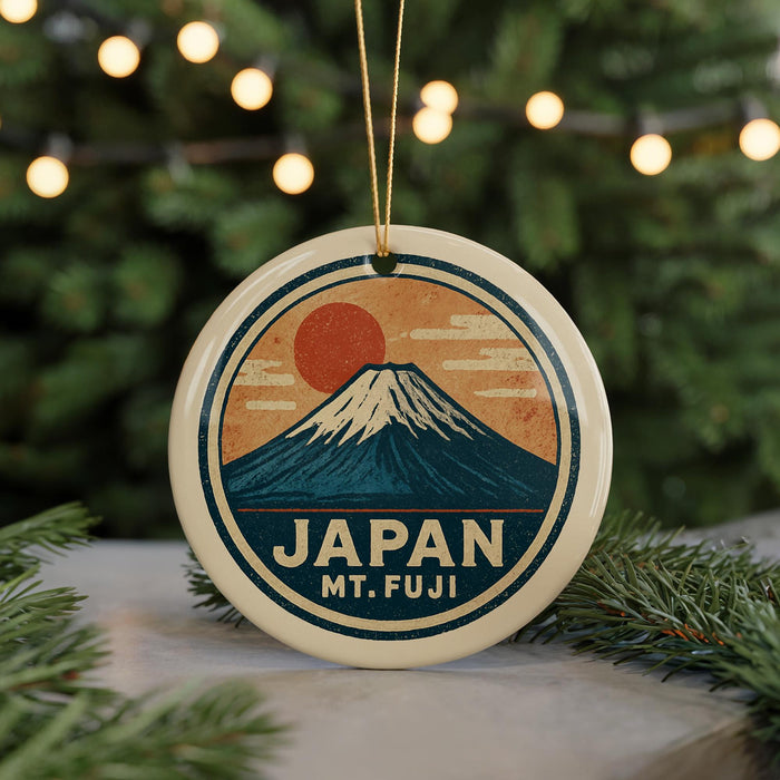 A circular ornament with a mountain and sun design, featuring the text "JAPAN MT. FUJI" on it, is hanging from a string.
