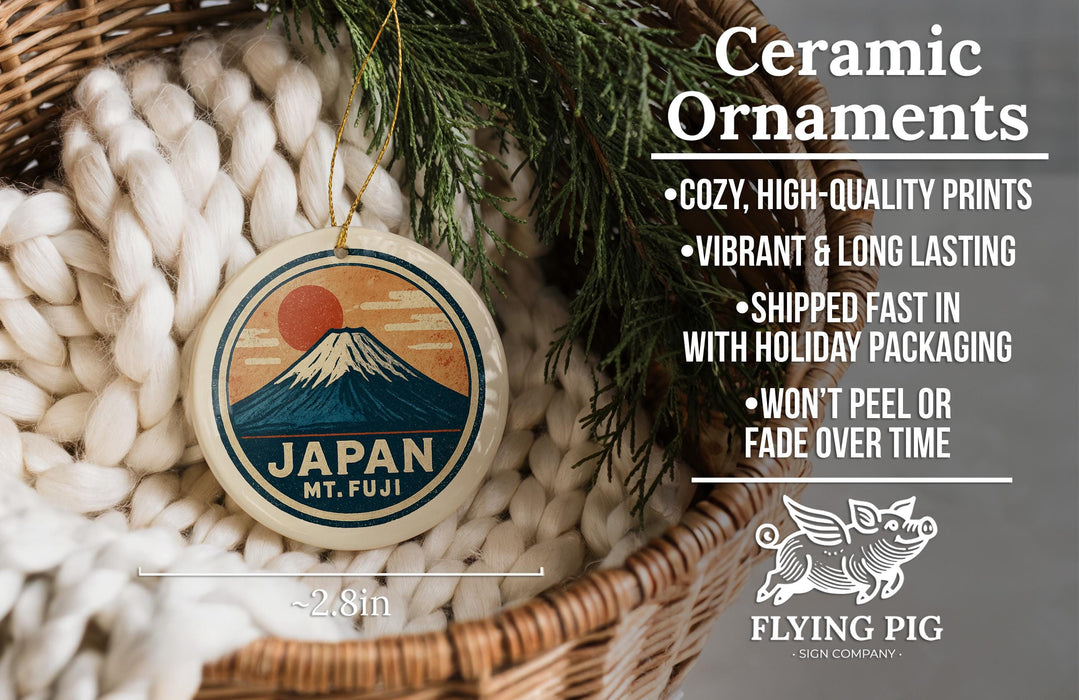 Ceramic ornaments featuring a Japanese mountain landscape, with a wicker basket and greenery in the background.