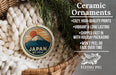 Ceramic ornaments featuring a Japanese mountain landscape, with a wicker basket and greenery in the background.