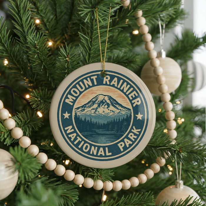 A Christmas tree decorated with ornaments, including a circular ornament with the text "Mount Rainier National Park" and a mountain landscape design.