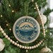 A Christmas tree decorated with ornaments, including a circular ornament with the text "Mount Rainier National Park" and a mountain landscape design.