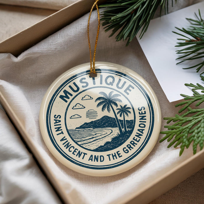 A circular ornament with a palm tree and beach scene, surrounded by text, is displayed in a box with pine branches.