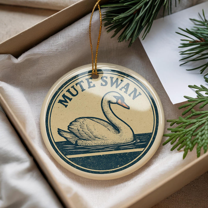 A round ornament with a swan image and the text "MUTE SWAN" is displayed in a box with pine branches.