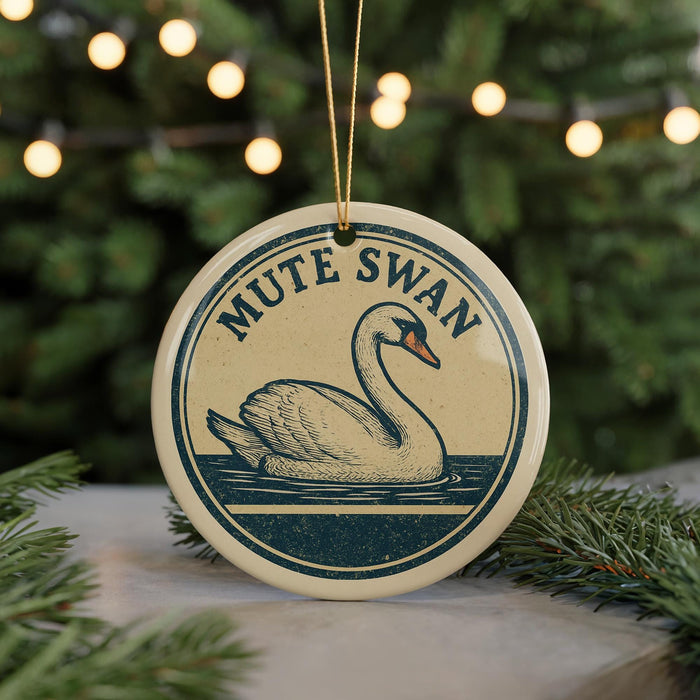 A round ornament featuring a swan swimming in a body of water, with the text "MUTE SWAN" displayed on it.