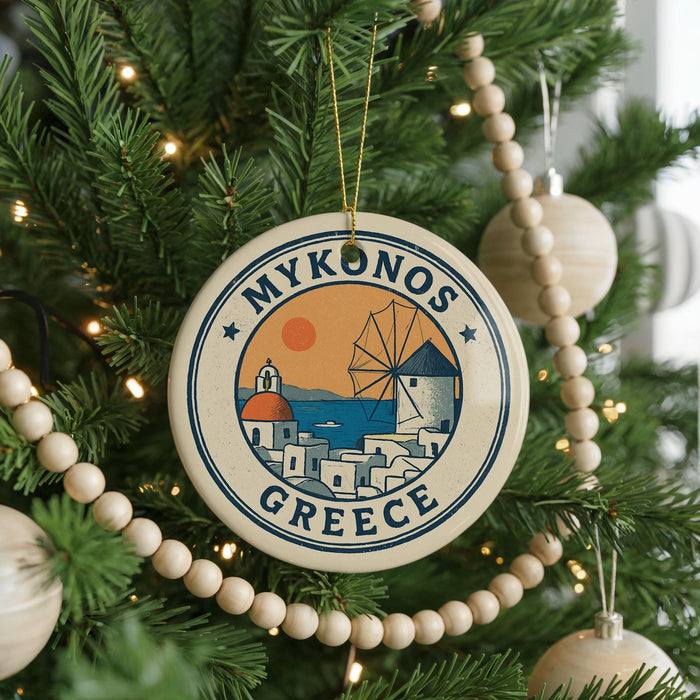 A circular ornament on a Christmas tree, featuring a design of a windmill and the text "MYKONOS GREECE".