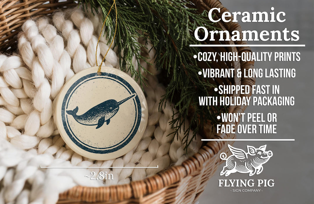 Ceramic ornaments, featuring a ceramic ornament with a blue and white design depicting a narwhal, are displayed in a wicker basket.