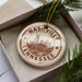 A circular ornament with the text "NASHVILLE TENNESSEE" and an illustration of a city skyline, hanging from a string.
