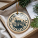 A circular ornament with the text "NEUCHWANSTEIN CASTLE GERMANY" printed on it, hanging from a string.