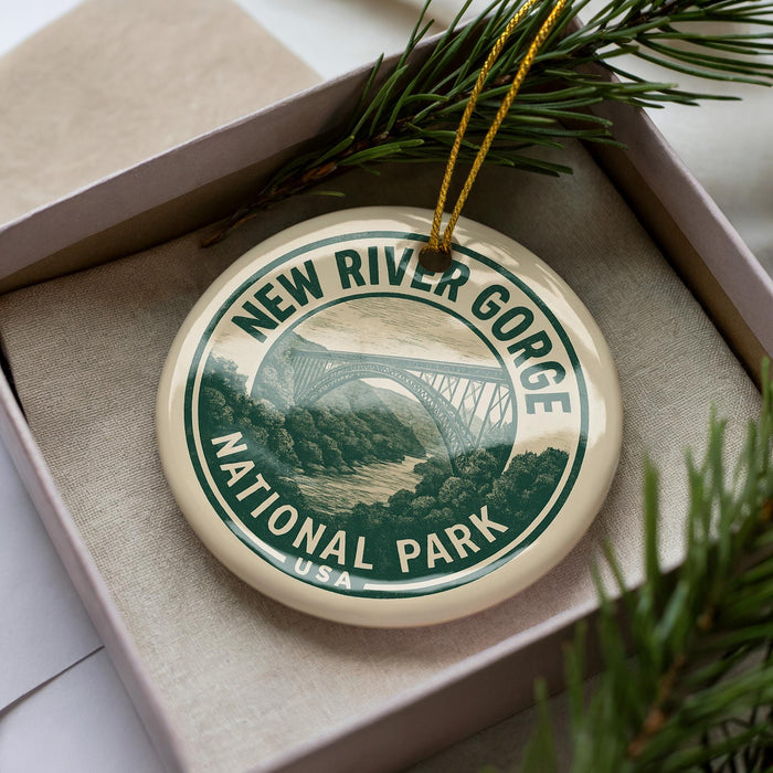 A circular ornament with the text "NEW RIVER GORGE NATIONAL PARK USA" printed on it, surrounded by pine branches.