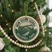 A Christmas tree decorated with ornaments, including a circular ornament with the text "NEW RIVER GORGE NATIONAL PARK USA" and a bridge illustration.