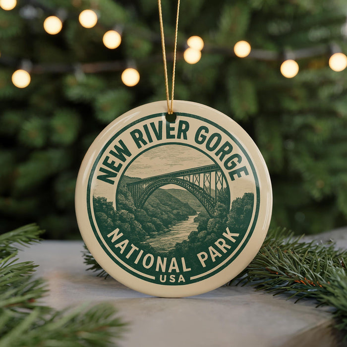 A circular ornament with the text "NEW RIVER GORGE NATIONAL PARK USA" and an illustration of a bridge in the background, hanging from a string.