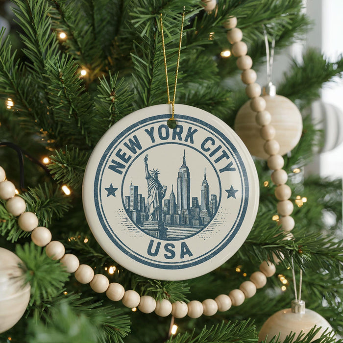 A Christmas tree decorated with ornaments, including a circular ornament with the text "NEW YORK CITY USA" and a depiction of the Statue of Liberty.