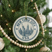 A Christmas tree decorated with ornaments, including a circular ornament with the text "NEW YORK CITY USA" and a depiction of the Statue of Liberty.