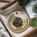 A circular ornament with a dog's head and the text "NEWFOUNDLAND DOG" printed on it, hanging from a string.