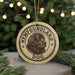 A circular ornament featuring a black and white illustration of a dog's head, with the text "NEWFOUNDLAND DOG" printed on it, hanging from a string.