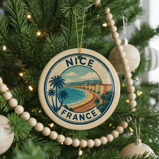 A circular ornament on a Christmas tree with the text "NICE FRANCE" and a beach scene illustration.