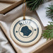 A decorative ornament with the word "NIUE" on it, surrounded by pine branches and a white paper.