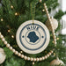 A Christmas tree decorated with ornaments, including a circular ornament with the word "NIUE" and a silhouette of a map of Niue.