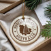 A round ornament with the text "NORFOLK ISLAND AUSTRALIA" printed on it, surrounded by pine branches and a white paper.