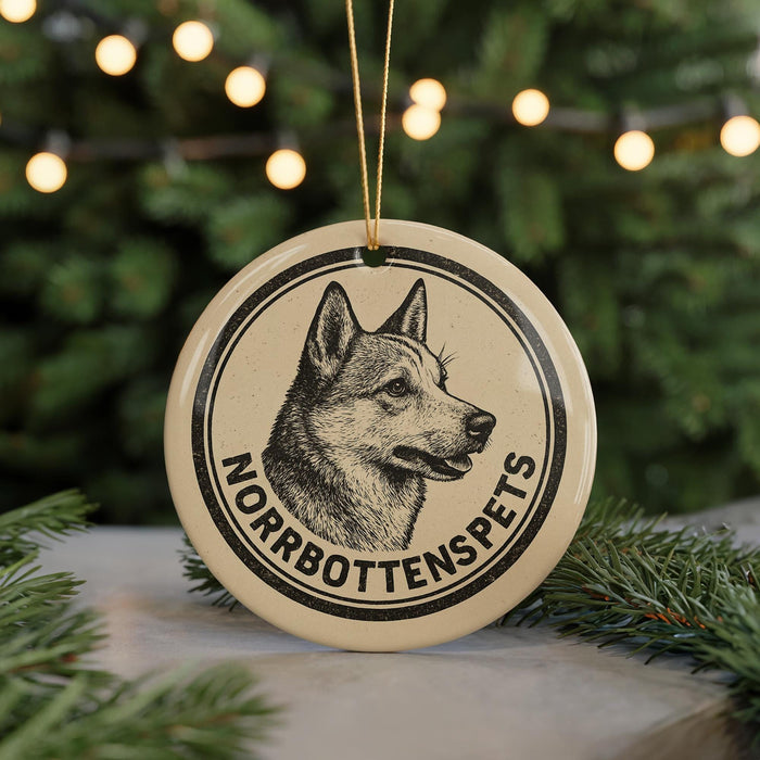 A round ornament featuring a black and white illustration of a dog's head, with the text "NORROBOTTENSPEATS" around the edge.