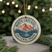 A round ornament with a mountain and pine tree design, featuring the text "NORTH CASCADES NATIONAL FPRK" and "U.S.A."