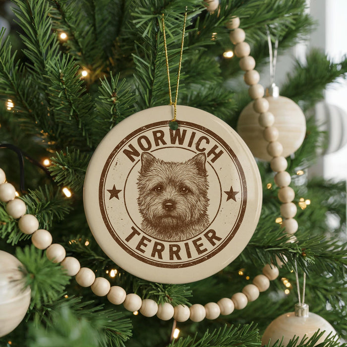 A Christmas tree decorated with ornaments, including a circular ornament with a terrier dog image and the text "NORWICH TERRIER".