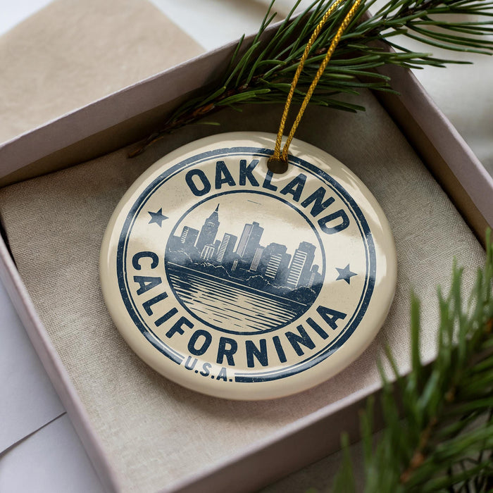 A circular ornament with the text "OAKLAND CALIFORNIA" and a graphic of a city skyline, hanging from a string.