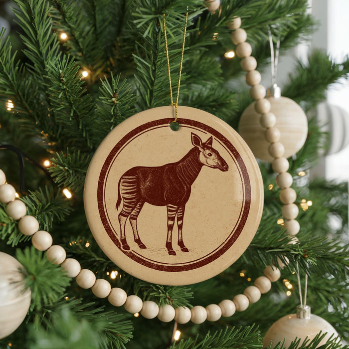 A Christmas tree decorated with ornaments, including a circular ornament featuring a zebra silhouette.