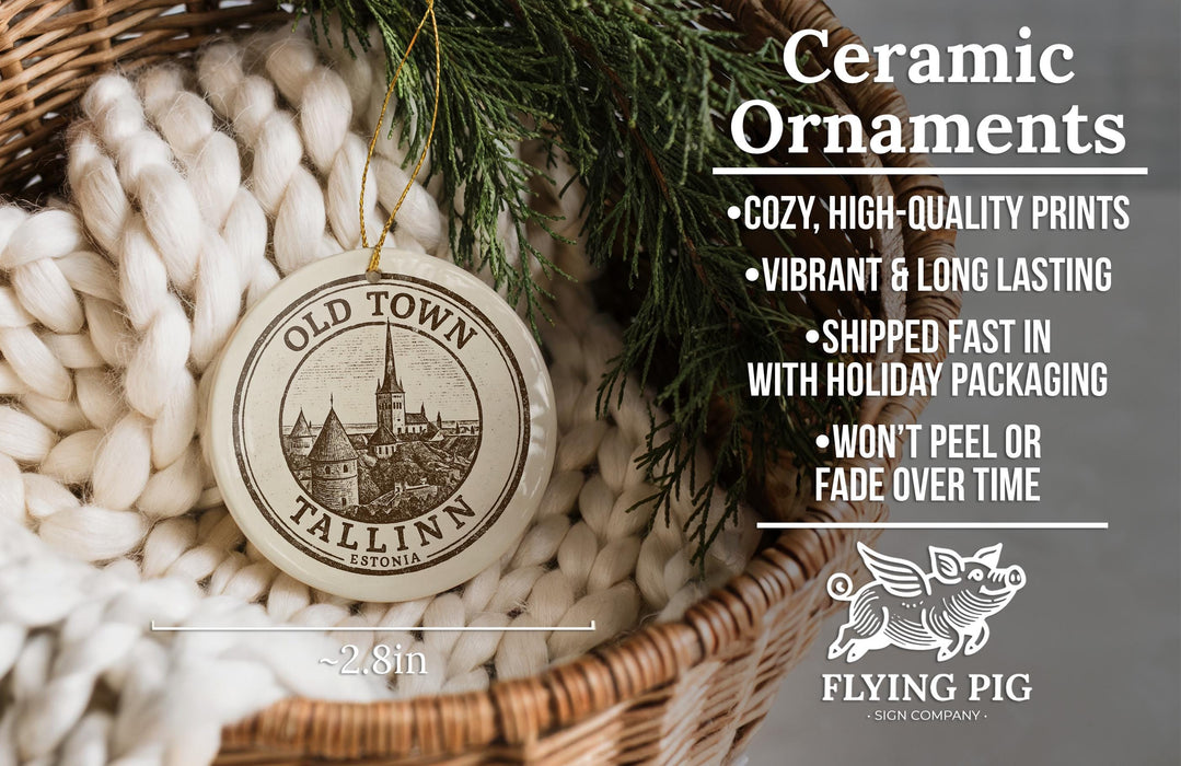 Ceramic ornaments, featuring a round ornament with a cityscape design, are displayed in a woven basket.