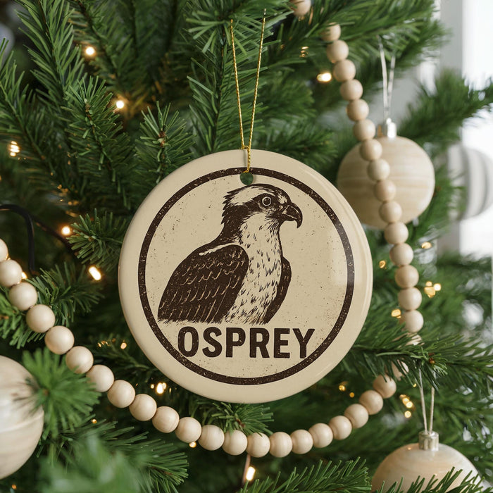 A Christmas tree decorated with ornaments, including a circular ornament with an image of an Osprey and the word "OSPREY" written on it.