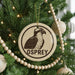 A Christmas tree decorated with ornaments, including a circular ornament with an image of an Osprey and the word "OSPREY" written on it.