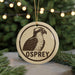 A circular ornament featuring an illustration of an Osprey bird, with the word "OSPREY" written below it.