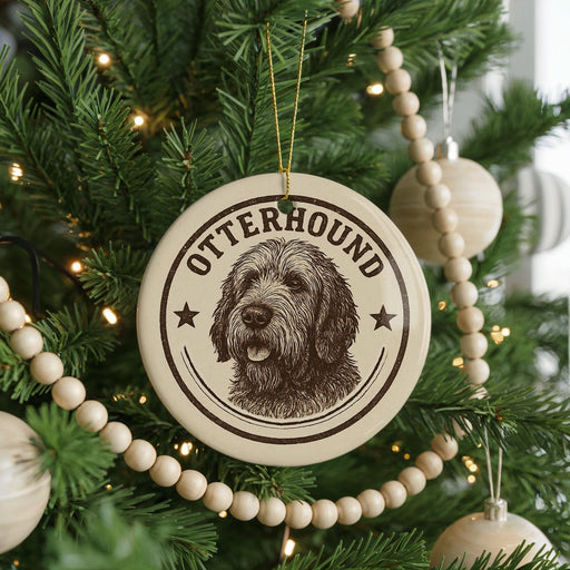 A Christmas tree decorated with ornaments, including a circular ornament with a dog image and the word "OTTERHOUND" written on it.
