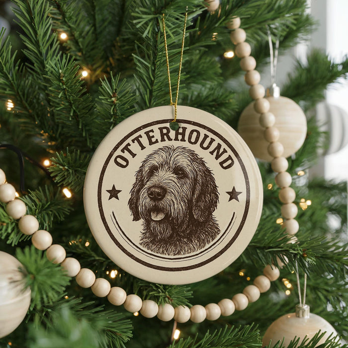 A Christmas tree decorated with ornaments, including a circular ornament with a dog image and the word "OTTERHOUND" written on it.