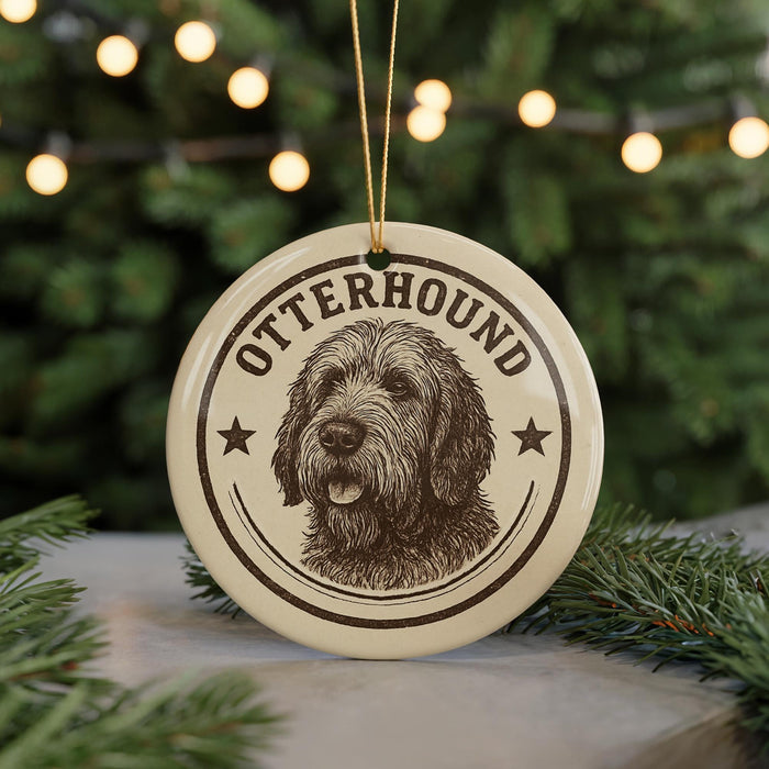 A round ornament with a dog's head and the word "OTTERHOUND" printed on it, hanging from a string.