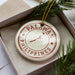 A circular ornament with the text "PALAWAN PHILIPPINES" printed on it, surrounded by pine branches.