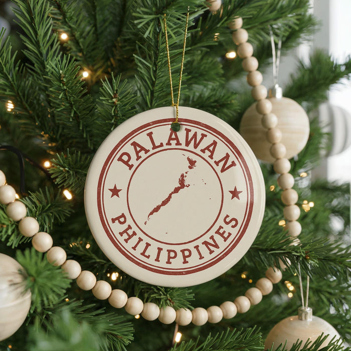 A Christmas tree decorated with ornaments, including a circular ornament with the text "PALAWAN PHILIPPINES" and a map of the Philippines.